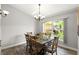 Dining room featuring wood flooring, a wooden table and chairs, and natural light from a large window at 3132 Mango Tree Dr, Edgewater, FL 32141