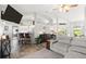 Open-concept living room showcasing wood flooring, breakfast bar seating, and seamless flow into the kitchen at 3132 Mango Tree Dr, Edgewater, FL 32141
