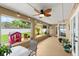 Enclosed patio with ceiling fan, view of the landscaped backyard, and access to the outdoors at 3132 Mango Tree Dr, Edgewater, FL 32141