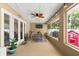 Inviting patio with a ceiling fan, outdoor seating, and a screen enclosure providing bug-free relaxation at 3132 Mango Tree Dr, Edgewater, FL 32141
