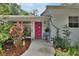 Inviting home entrance with a bright pink door, ample natural light, and landscaped front yard at 319 N Salisbury Ave, Deland, FL 32720