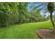 Expansive backyard with lush green grass and mature trees offering privacy and a serene outdoor space at 33 Coquina Ridge Way, Ormond Beach, FL 32174