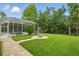 Backyard featuring a screened pool and lush green lawn at 33 Coquina Ridge Way, Ormond Beach, FL 32174
