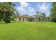 Backyard view of a screened pool and expansive green lawn at 33 Coquina Ridge Way, Ormond Beach, FL 32174