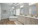 Bright bathroom with dual sink vanity, tiled floors, a soaking tub, and a glass shower enclosure at 33 Coquina Ridge Way, Ormond Beach, FL 32174