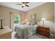 Cozy bedroom with a ceiling fan, side tables, and window with a green view at 33 Coquina Ridge Way, Ormond Beach, FL 32174