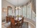 Formal dining room boasts a large window, chandelier, and stylish wooden furniture at 33 Coquina Ridge Way, Ormond Beach, FL 32174