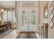 Elegant foyer featuring double glass doors and views into dining room at 33 Coquina Ridge Way, Ormond Beach, FL 32174