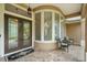 Covered entryway with decorative double doors, transom window, and seating area at 33 Coquina Ridge Way, Ormond Beach, FL 32174