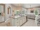 Open concept kitchen with granite island, seamlessly connects to the living room and screened lanai with pool view at 33 Coquina Ridge Way, Ormond Beach, FL 32174