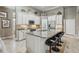 Bright kitchen boasts white cabinets, granite counters, stainless steel appliances, and an island with bar stool seating at 33 Coquina Ridge Way, Ormond Beach, FL 32174