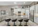 Open kitchen with an island and bar stools connects seamlessly to the living area, fostering a social atmosphere at 33 Coquina Ridge Way, Ormond Beach, FL 32174