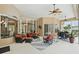 Comfortable outdoor lanai with ceiling fans, a BBQ, and multiple sitting and eating areas at 33 Coquina Ridge Way, Ormond Beach, FL 32174