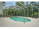 View of the screened pool and spa with chairs for relaxing at 33 Coquina Ridge Way, Ormond Beach, FL 32174