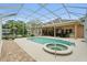 A screened pool and spa with an outdoor kitchen and dining area at 33 Coquina Ridge Way, Ormond Beach, FL 32174
