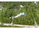 Aerial view showcasing a beautiful home with a private pool, pond, and lush greenery at 3671 Plantation Dr, Ormond Beach, FL 32174