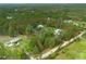 Aerial view of a property surrounded by lush greenery, featuring a pond, home, and spacious land at 3671 Plantation Dr, Ormond Beach, FL 32174
