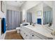 Well-lit bathroom with marble counter, a shower with curtain, and coordinated fixtures at 3671 Plantation Dr, Ormond Beach, FL 32174