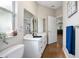 Bathroom featuring white vanity with double mirrors and a window for natural light at 3671 Plantation Dr, Ormond Beach, FL 32174