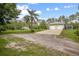 Exterior of home featuring a long driveway leading to a two-car garage and lush green landscaping at 3671 Plantation Dr, Ormond Beach, FL 32174
