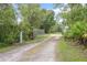 Gated entrance to property surrounded by lush greenery and trees, creating a private and secluded setting at 3671 Plantation Dr, Ormond Beach, FL 32174