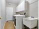 Laundry room with front load washer and dryer, sink and overhead storage cabinets at 3671 Plantation Dr, Ormond Beach, FL 32174