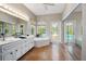 Sunlit bathroom with dual sinks, a garden tub, and outdoor access to the pool deck at 3671 Plantation Dr, Ormond Beach, FL 32174