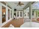 Relaxing covered patio featuring a ceiling fan and comfortable seating area, accessible through French doors at 3671 Plantation Dr, Ormond Beach, FL 32174