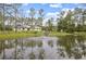 Scenic view of a home from across the pond, complete with a fountain and dock enhancing its natural beauty at 3671 Plantation Dr, Ormond Beach, FL 32174