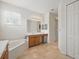 Bathroom with tiled floor, tub, vanity, and walk-in closet at 3839 Calliope Ave, Port Orange, FL 32129