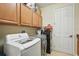 Functional laundry room featuring front-load washer and dryer, complemented by storage cabinets at 3839 Calliope Ave, Port Orange, FL 32129