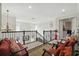 Bright upstairs landing with seating, carpet runner and decorative railing leading to the bedrooms at 3839 Calliope Ave, Port Orange, FL 32129