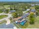 Aerial view of home featuring solar panels and a screened-in pool surrounded by a white fence at 4 Brandy Hills Dr, Port Orange, FL 32129