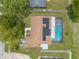 Birds-eye view of a property with a screened-in pool, solar panels, and an in-ground pool at 4 Brandy Hills Dr, Port Orange, FL 32129