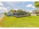 Grassy backyard with a screened pool enclosure and storage shed, providing ample space for recreation and storage at 4 Brandy Hills Dr, Port Orange, FL 32129