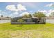 Large backyard showcasing a screened pool enclosure, perfect for enjoying outdoor living in a private setting at 4 Brandy Hills Dr, Port Orange, FL 32129