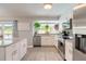 Bright kitchen with stainless steel appliances, granite countertops, and a large window overlooking the backyard at 4 Brandy Hills Dr, Port Orange, FL 32129
