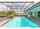 Inviting screened pool with tropical landscaping and covered deck, perfect for outdoor relaxation and entertaining at 4 Brandy Hills Dr, Port Orange, FL 32129