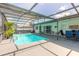 Large in-ground swimming pool surrounded by a screened enclosure, patio area, and beautiful outdoor landscaping at 4 Brandy Hills Dr, Port Orange, FL 32129