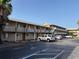 Exterior of a multi-story building with ample parking and balconies under a clear, sunny sky at 411 N Halifax Ave # 208, Daytona Beach, FL 32118