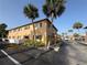 Tan two-story apartment building featuring palm trees and convenient parking at 411 N Halifax Ave # 208, Daytona Beach, FL 32118