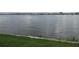Calm water view with the distant horizon and boats under a cloudy sky, next to green grass at 411 N Halifax Ave # 208, Daytona Beach, FL 32118