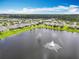 Community aerial showcasing homes near a lake with a fountain amidst a green landscape at 422 Armoyan Way, New Smyrna Beach, FL 32168
