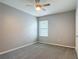 A comfortable bedroom with soft carpet, a modern ceiling fan, and a window letting in natural light at 422 Armoyan Way, New Smyrna Beach, FL 32168