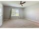 Neutral bedroom with carpet and fan features a window with blinds, offering natural light and ventilation at 422 Armoyan Way, New Smyrna Beach, FL 32168