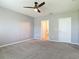 The room features a ceiling fan, neutral paint, and a doorway to a light and airy bathroom at 422 Armoyan Way, New Smyrna Beach, FL 32168