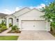 Exterior shot of the house displaying the two-car garage with a driveway and landscaping at 422 Armoyan Way, New Smyrna Beach, FL 32168