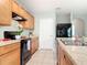 The kitchen features sleek black appliances, wood cabinetry, and a tile backsplash at 422 Armoyan Way, New Smyrna Beach, FL 32168