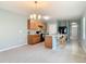 Bright kitchen with an island and barstool seating open to the carpeted living room at 422 Armoyan Way, New Smyrna Beach, FL 32168