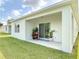Covered patio with outdoor seating, sliding glass doors and manicured lawn at 422 Armoyan Way, New Smyrna Beach, FL 32168